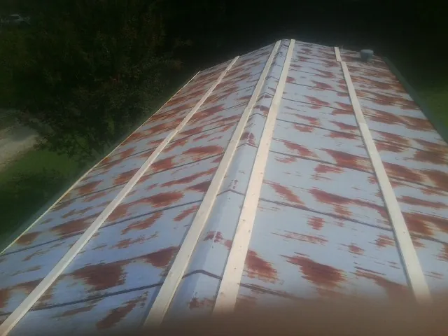 Rusted metal roof panels with new wood purlins before replacement — Storm Damage Roof Repair in Ilion by Roofing Brothers