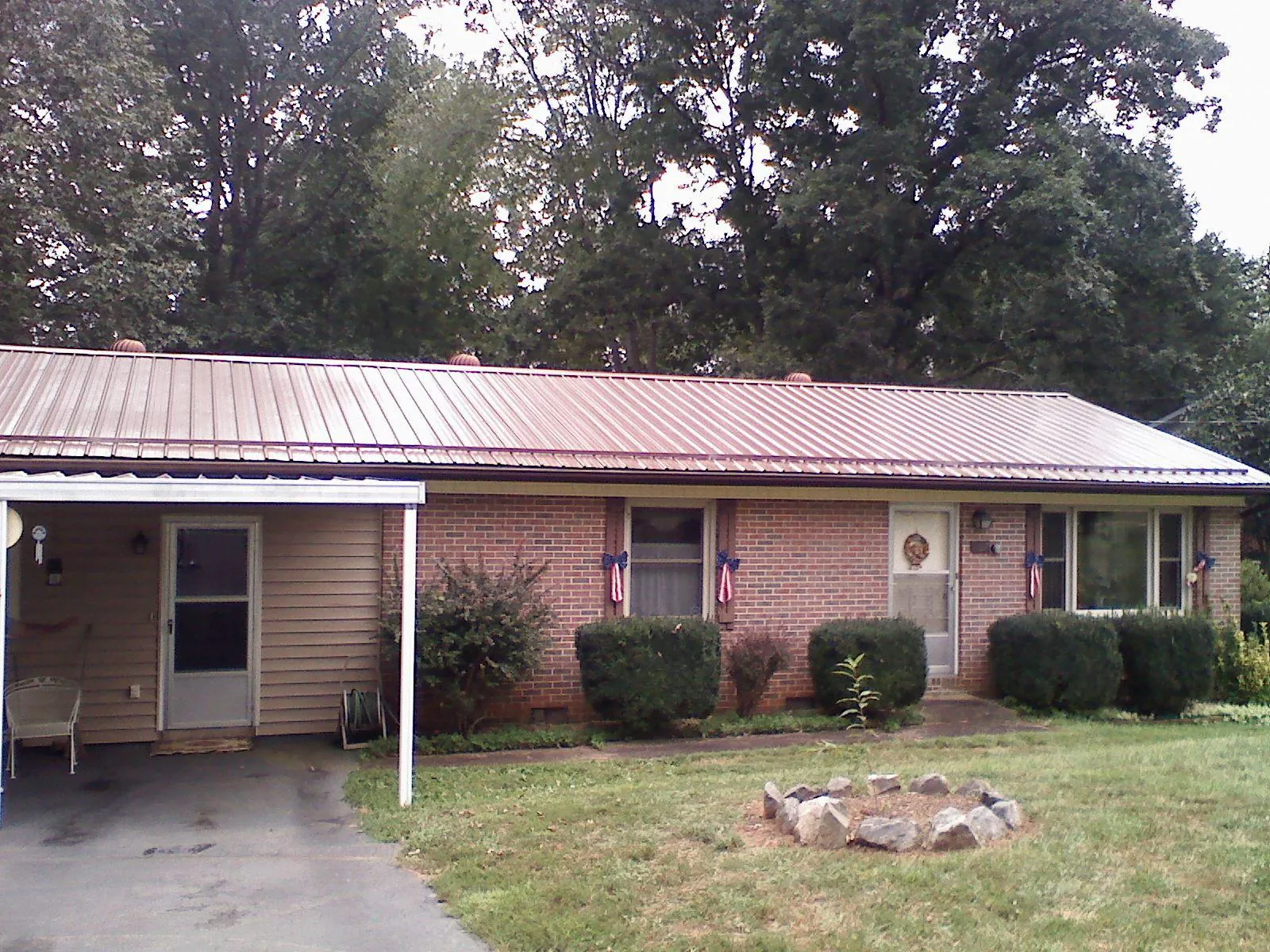 Bronze metal roof and carport on a brick ranch home — Roof Repair work by our crew in Ilion